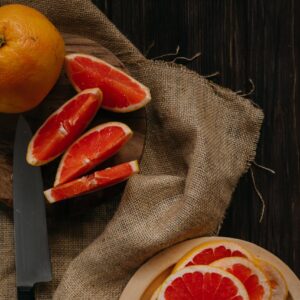 Sliced grapefruit on a wooden table, perfect for healthy eating and wellness themes.