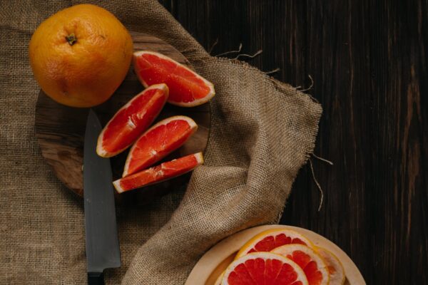 Sliced grapefruit on a wooden table, perfect for healthy eating and wellness themes.