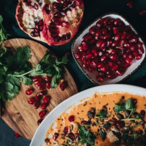 Delicious vegan dish garnished with pomegranate and fresh cilantro, perfect for fall dining.